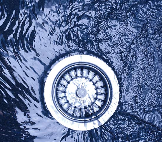 Water slowly draining in a sink