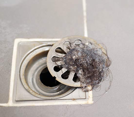 Drain with a removed blockage of hair