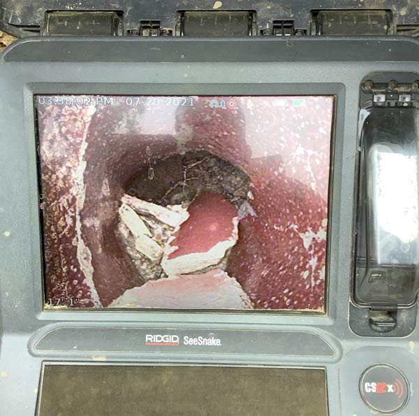 Screen showing camera view of a broken pipe