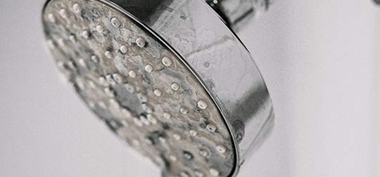 Limescale from hard water on a shower head