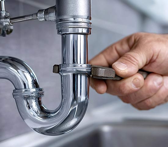 Plumbing using a wrench on plumbing pipes