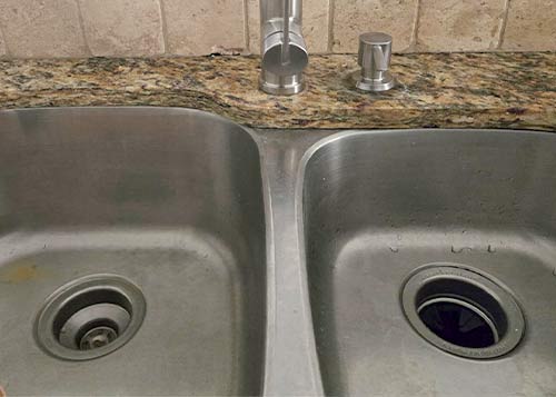 Kitchen sink with two basins including a garbage disposal